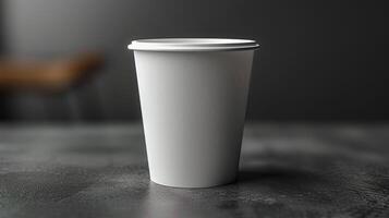 A white paper cup is sitting on a table photo