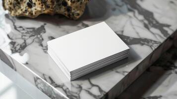 A stack of white business cards sits on a marble countertop photo