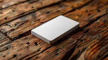 A white card is sitting on a wooden table photo