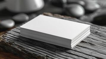 A stack of white business cards sits on a wooden surface photo