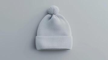 A gray knit hat with a pom pom on top photo