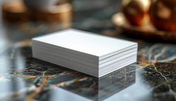 A stack of white business cards sits on a marble countertop photo