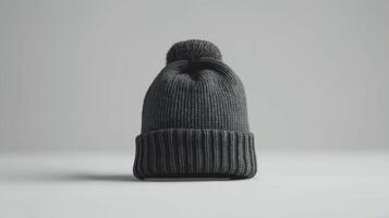 A black knit hat with a pom pom on top photo