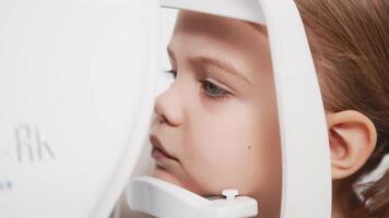 A child being examined with a slit lamp. Device with a microscope and focused light to assess lens and cornea conditions. Perfect for vision diagnostics ads video