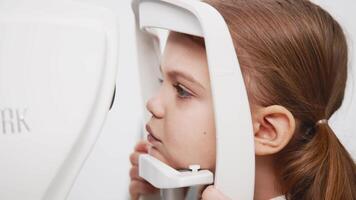 A child being examined with a slit lamp. Device with a microscope and focused light to assess lens and cornea conditions. Perfect for vision diagnostics ads video