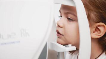 A child being examined with a slit lamp. Device with a microscope and focused light to assess lens and cornea conditions. Perfect for vision diagnostics ads video