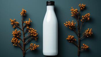 A bottle of milk is placed on a table next to some leaves photo