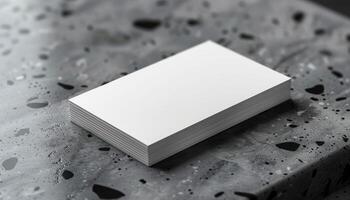 A white business card sits on a table with a black background photo
