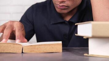 A man is reading a book while sitting at a table video