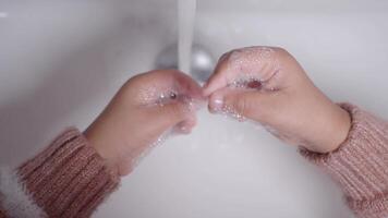 child making a cleansing gesture with soap and water on hands video