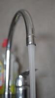 A CloseUp Image of Water Flowing Beautifully from a Kitchen Faucet in a Modern Setting video