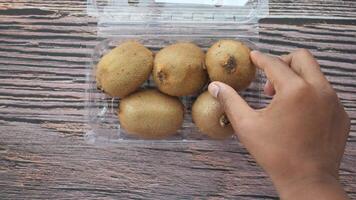 Fresh and delicious Kiwi Fruits neatly arranged in Plastic Packaging on a Wooden Table surface video