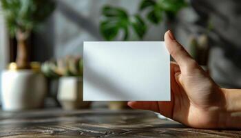 A hand holding a white card with no writing on it photo