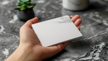 A hand holding a white card with a black border photo
