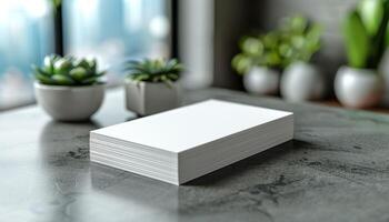 A stack of white paper is on a table next to a potted plant photo