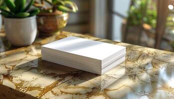 A stack of white papers is on a table in front of a potted plant photo