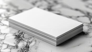 A stack of white business cards sits on a marble countertop photo