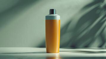 A bottle of lotion is sitting on a table in front of a green leafy plant photo