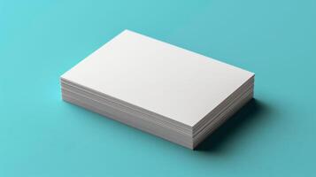 A stack of white business cards sits on a blue surface photo