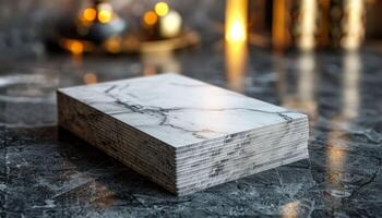 A white marble block with a black and white pattern sits on a dark surface photo