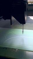 Thin applicator of automatic machine draws lines on the glass. video