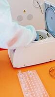 Laboratory assistant near automated device for making analysis. Female worker in protective uniform takes out test tubes from centrifuge in lab. Vertical video