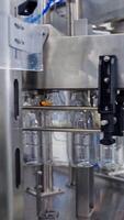 Bottles for milk on automatic production line. Dairy production in robotic factory. Empty bottles are filling with milk on manufacturing line. Vertical video