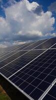 solar painel em uma moderno estação dentro uma brilhante dia. branco nuvens sobre a solar painel. alternativo limpar \ limpo eletricidade. Inovativa tecnologia para crio renovável energia em uma poder plantar. vertical video