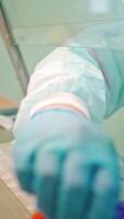 Worker in the laboratory. Laboratory technician in protective uniform is making research with different samples in clinic. Close-up. Vertical video