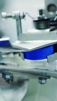 Automated machine covering plastic bottle with lid. Dairy production. Mechanical process of putting cover on a bottle with milk in a modern factory. Vertical video