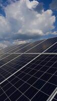 solar painéis em uma moderno elétrico estação. a nuvens estão refletido em a superfície do a solar painéis. alternativo limpar \ limpo eletricidade. vertical video