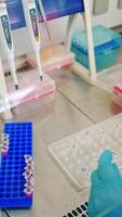 Hands in sterile gloves working with test tubes. Medical worker fills vials with liquid on the table in the laboratory. Vertical video
