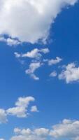 duveteux peu des nuages dans le bleu ligne d'horizon. terrifiant laps de temps de le cloudscape en mouvement dans le été ciel. verticale video