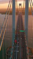 Beautiful bridge with motorways for transport. Top view. Huge structure over the river in the rays of setting sun. Vertical video