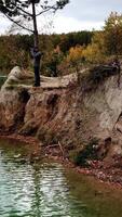 Man taking photo of landscape. Aerial view of man photographer taking photo on lake shore Vertical video