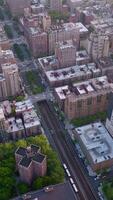 Multi-storied buildings of densely-built quarters of metropolis. Busy city at daytime. Aerial perspective. Vertical video