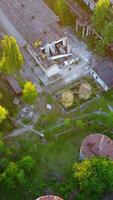 Abandoned Warehouses And Factories. Top view of the abandoned factory with broken windows and walls Vertical video