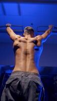Man doing pull up exercise. Young man doing pull ups on horizontal bar indoors. Vertical video