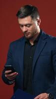 Man with mobile phone. Businessman with smartphone texting. Vertical video