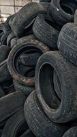 Lot of old tires from cars. Second hand tyres stacked up at old dump Vertical video