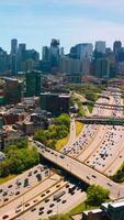 Broad multi-lane road going through the busy city. Bright and diverse architecture of Chicago at the backdrop of skyscrapers. Vertical video