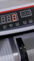 Cash money counting machine. Banknote counter are counting hundred dollar bills. Close-up Vertical video