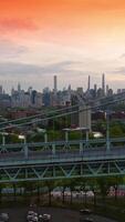 Automobiles riding quickly along the large bridge. Beautiful New York architecture at backdrop. Vertical video