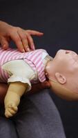 Practicing reanimation of infants. Medic shows tehnique with two fingers. Appropriate methods of first medical help. Vertical video