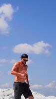 Man going down on mountain. Sportive man going down from steep descent of mountain Vertical video