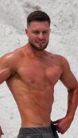 Bodybuilder athlete showing muscles. Handsome man with big muscles posing at the camera Vertical video
