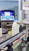 Conveyor with milk bottles. Blue covers on plastic bottles with milk inside at factory Vertical video