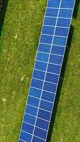 Photovoltaic solar panels. High angle view of solar panels on energy farm in rural Vertical video