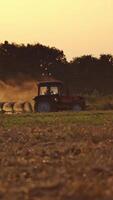Tractor working on the farm. Tractor plowing fields, preparing land for sowing Vertical video