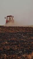 Tractor ploughing a field. Scale farming with tractor and plow in field Vertical video